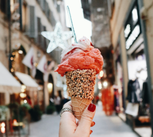 hand holding pink gelato on a cone